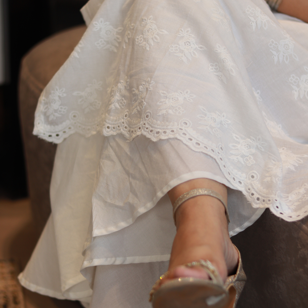 Close-up of a person wearing a white lace dress with a blurred background